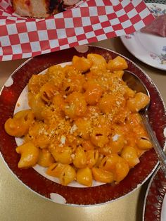 a red and white plate topped with macaroni and cheese