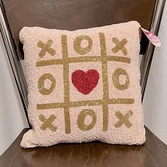 a decorative pillow sitting on top of a wooden chair next to a red and white heart