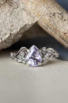 a white gold ring with an oval cut tanzante surrounded by leaves and diamonds