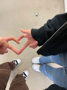 two people making a heart shape with their hands