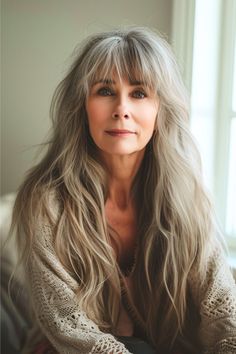 This layered shag with bangs floats its silver strands in soft layers. This look combines the elegance of grey with the youthful vitality of a full, textured wave. Click here to see more stunning long hairstyles for women over 60. Long Hair With Bangs 50 Year Old Women, Long Hair With Bangs And Layers, Shag With Bangs, Long Hair Older Women, Gray Blending, Layered Shag, 30 Year Old Man, Grey Blonde