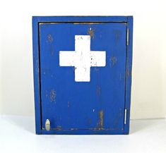 an old blue cabinet with a white cross painted on the front and bottom, against a white background