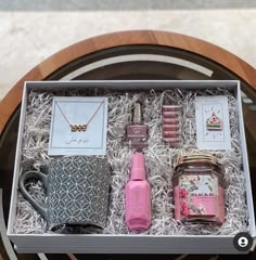 the contents of a gift box are displayed on a glass table with a wooden base