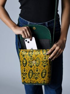 Soak in the Indianness of the Vibrant Heritage Ajrakh Satchel, a symphony of contrasting green and yellow hues adorned with ethnic ajrakh motifs. The structured tote, crafted from pure cotton fabric with broad leather handles, offers versatility as a crossbody or shoulder bag. The circular cutout on the leather flap, secured with a metal magnetic button, adds a unique touch. With a spacious central compartment, it accommodates books, journals, diaries, and even an iPad, blending ethnic tradition Traditional Green Shoulder Bag For Daily Use, Traditional Green Shoulder Bag For Everyday, Traditional Yellow Shoulder Bag For Daily Use, Traditional Yellow Shoulder Bag For Everyday Use, Ajrakh Motifs, Cool Messenger Bags, Best Travel Bags, Waxed Canvas Bag, Yellow Hues