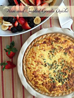 there is a pie on the table with strawberries and bananas in the bowl next to it