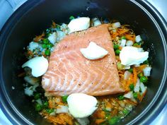 salmon and vegetables cooking in a pan on the stove