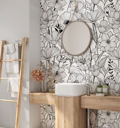 the bathroom is decorated in black and white with flowers on the wall next to the sink