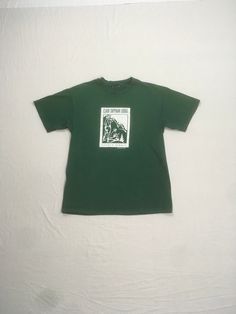 vintage 1990s t-shirt Clair Tapaan Lodge Donner Summit Established 1934 green tee w/white print image of 2 campers w/mountain peaks in the background good vintage condition w/some wear-small stain/paint spots-see photos no tag, cotton feel , single stitch fits like a xs/s-see below measures, lying flat, shoulder-18" chest-18" sleeve-7" length-26 1/2" Green Graphic Print T-shirt For Camping, Pre-shrunk Green T-shirt For Camping, Green Graphic Tee For Outdoor, Green Short Sleeve T-shirt For Outdoor, Green Pre-shrunk T-shirt For Camping, Green Graphic Tee For Outdoor Activities, Green Crew Neck T-shirt For Outdoor, Green T-shirt For Outdoor Activities, Green Letter Print T-shirt For Camping