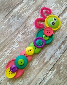 a toy with buttons on it sitting on top of a wooden floor next to a pair of scissors