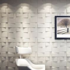 two white chairs in front of a wall with a tree on it and a framed photograph