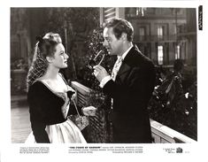 an old black and white photo of a man holding a wine glass next to a woman