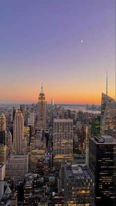 the city skyline is lit up at night, with skyscrapers in the foreground