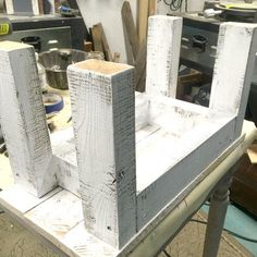 two wooden blocks sitting on top of a metal table in a room filled with tools