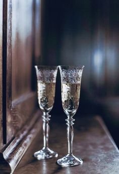 two champagne glasses sitting on top of a counter