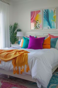 a white bed topped with lots of colorful pillows