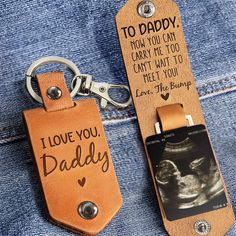 a pair of leather keychains with an i love you daddy tag attached to them