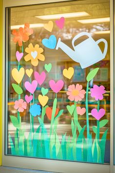 a window decorated with flowers and a watering can