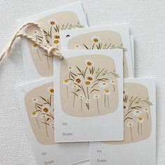 four cards with daisies on them are tied to a string and placed next to each other