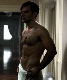 a shirtless man standing in front of a mirror with his hands on his hips