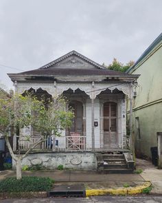 an old house with a tree in front of it and another building next to it