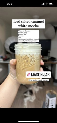 someone holding up a jar of iced salted caramel white mocha