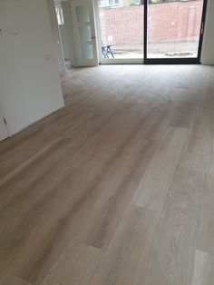 an empty room with wooden floors and sliding glass doors