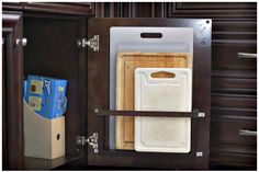 an open cabinet with cutting boards in it