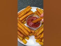 a plate with some french fries on it and ketchup in a small bowl