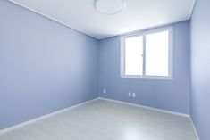 an empty room with blue walls and white floors