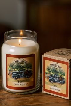 a candle sitting on top of a wooden table next to a box with a candle in it