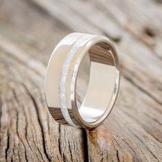 the wedding ring is made from wood and has a white ceramic inlay on it