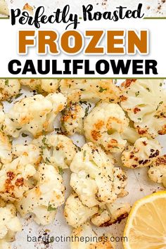 roasted cauliflower on a baking sheet with lemon wedges