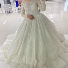 a woman in a wedding dress taking a selfie with her cell phone while wearing a tiara