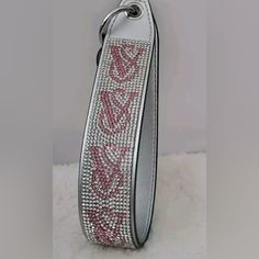 a silver belt with pink hearts on it