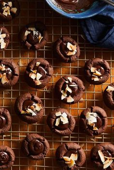 chocolate cookies are on a cooling rack next to a bowl of frosted caramel