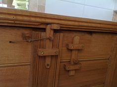 a close up of a wooden door with metal latches on the front and side