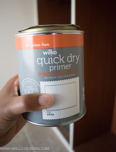 a person holding a can of paint in their hand