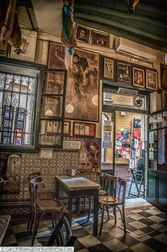 the inside of a restaurant with many pictures on the wall and tables in front of it