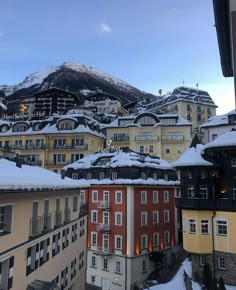 snow covered buildings and mountains in the background