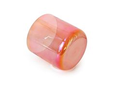 a pink and yellow glass object sitting on top of a white surface