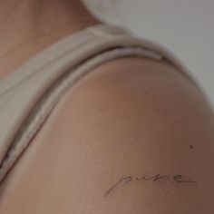 the back of a woman's shoulder with writing on it that says pure in cursive ink