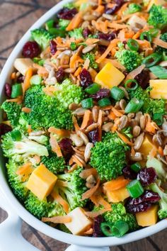 a bowl filled with broccoli, cranberries and nuts