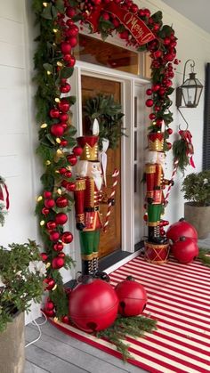 christmas decorations on the front door of a house with red and green ornaments around them