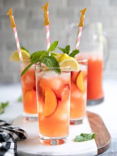 three glasses filled with fruit and ice on top of a table