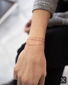 a woman's wrist with a thin line tattoo on it