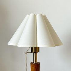 a lamp with a wooden base and white lampshade on it's side