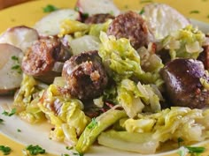 a white plate topped with meatballs and cabbage