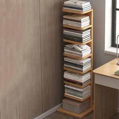 a stack of books sitting on top of a wooden shelf next to a window