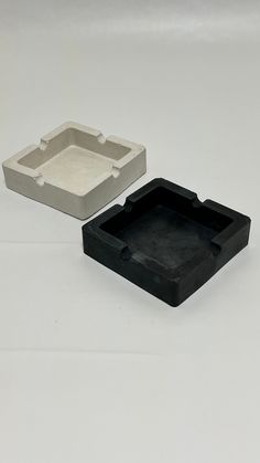 two black and white trays sitting next to each other