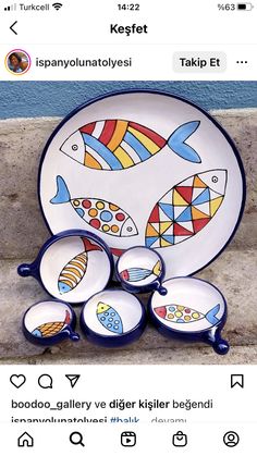 a plate with fish painted on it next to other plates